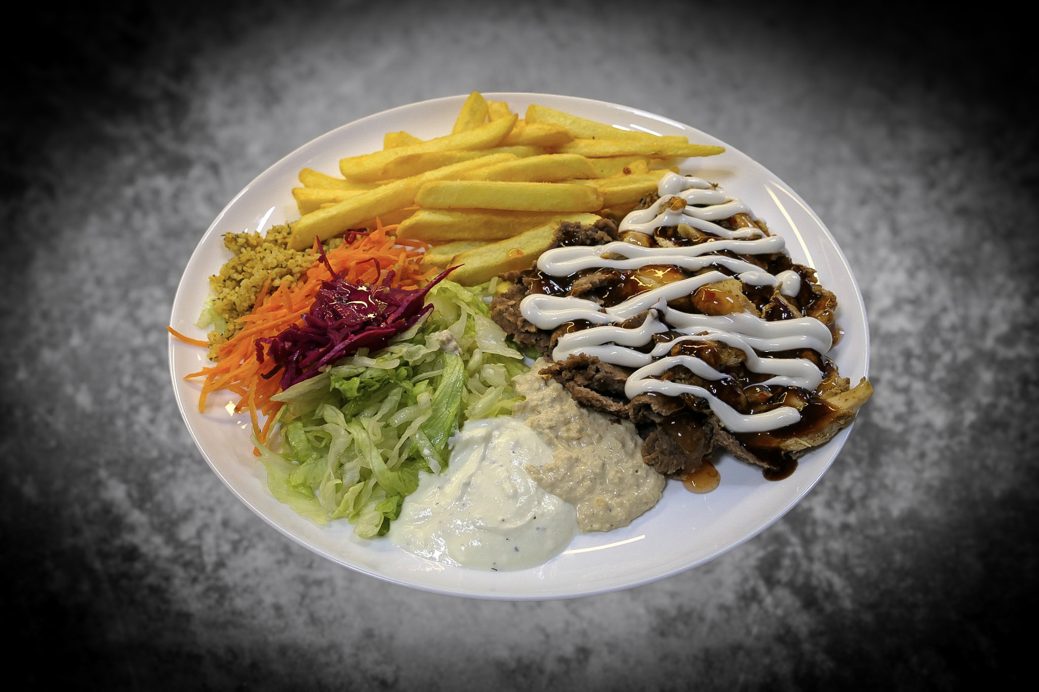 A halal snack pack with kebab meat, chips, salad and sauce